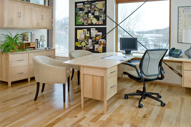 lovely office with desk, 2 client chairs and a custom cabinet against the back wall