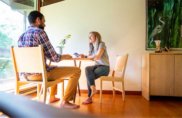 a couple chatting at a small table in a modern house