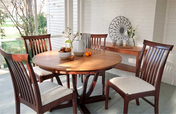 round dining table with chairs on screened in porch