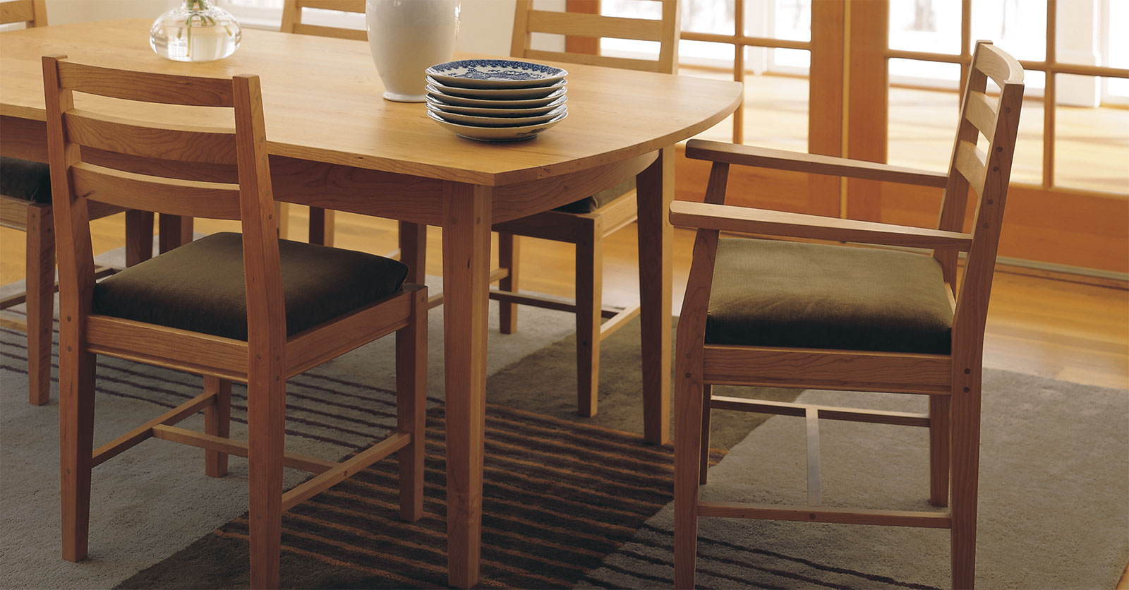 simple yet elegant dining room with view of arched end of table and arm chair