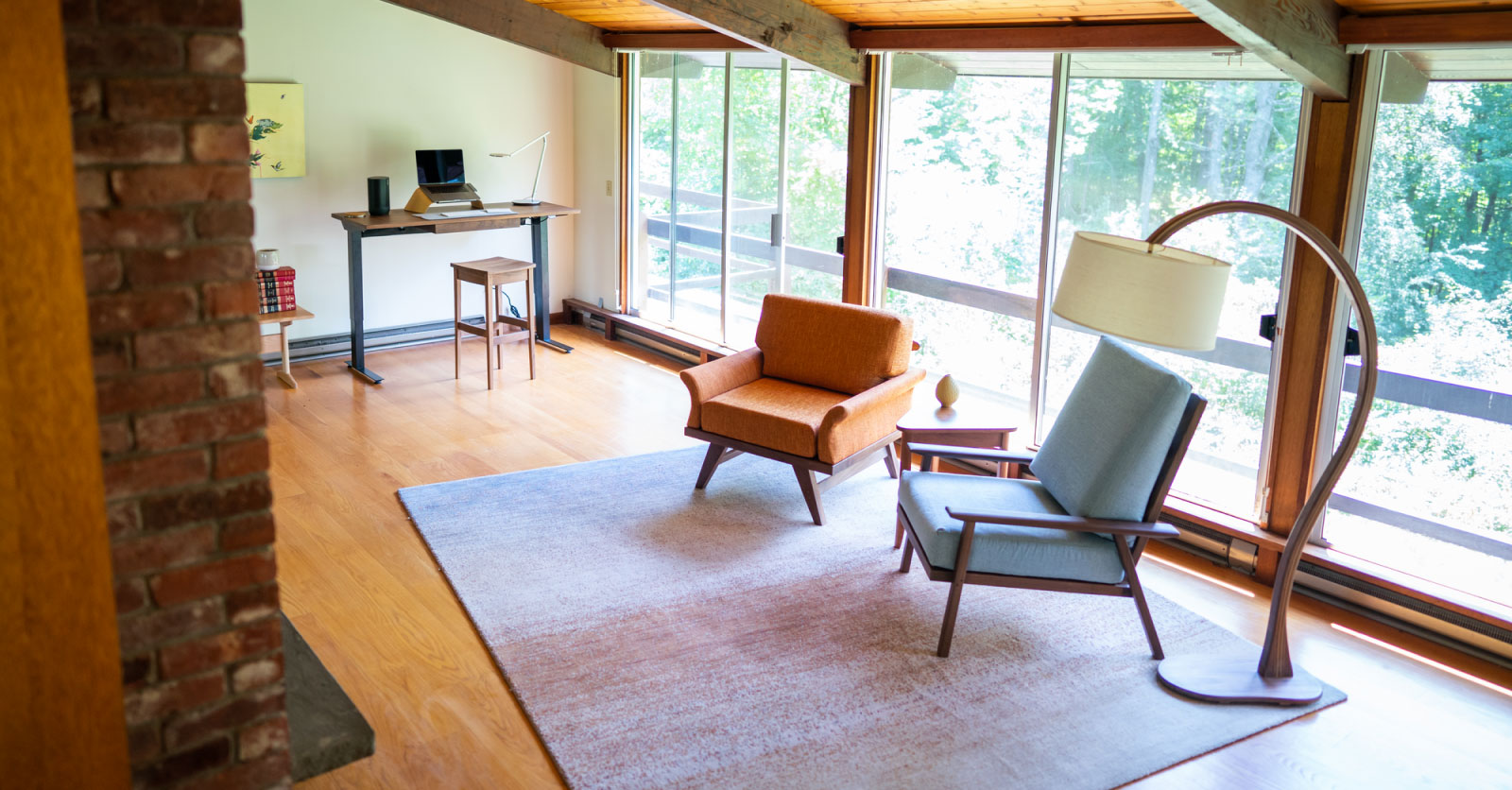 living room with 2 mid-century modern hairs, a standing table desk and a cool arched floor lamp