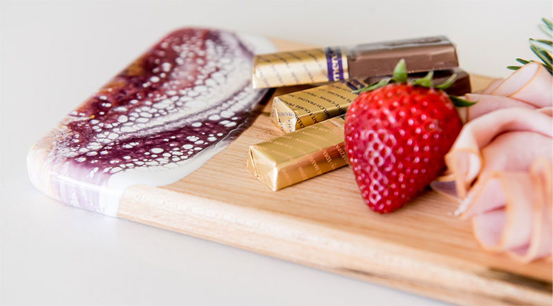 cutting board with cool colored epoxy end with fruit and chocolate