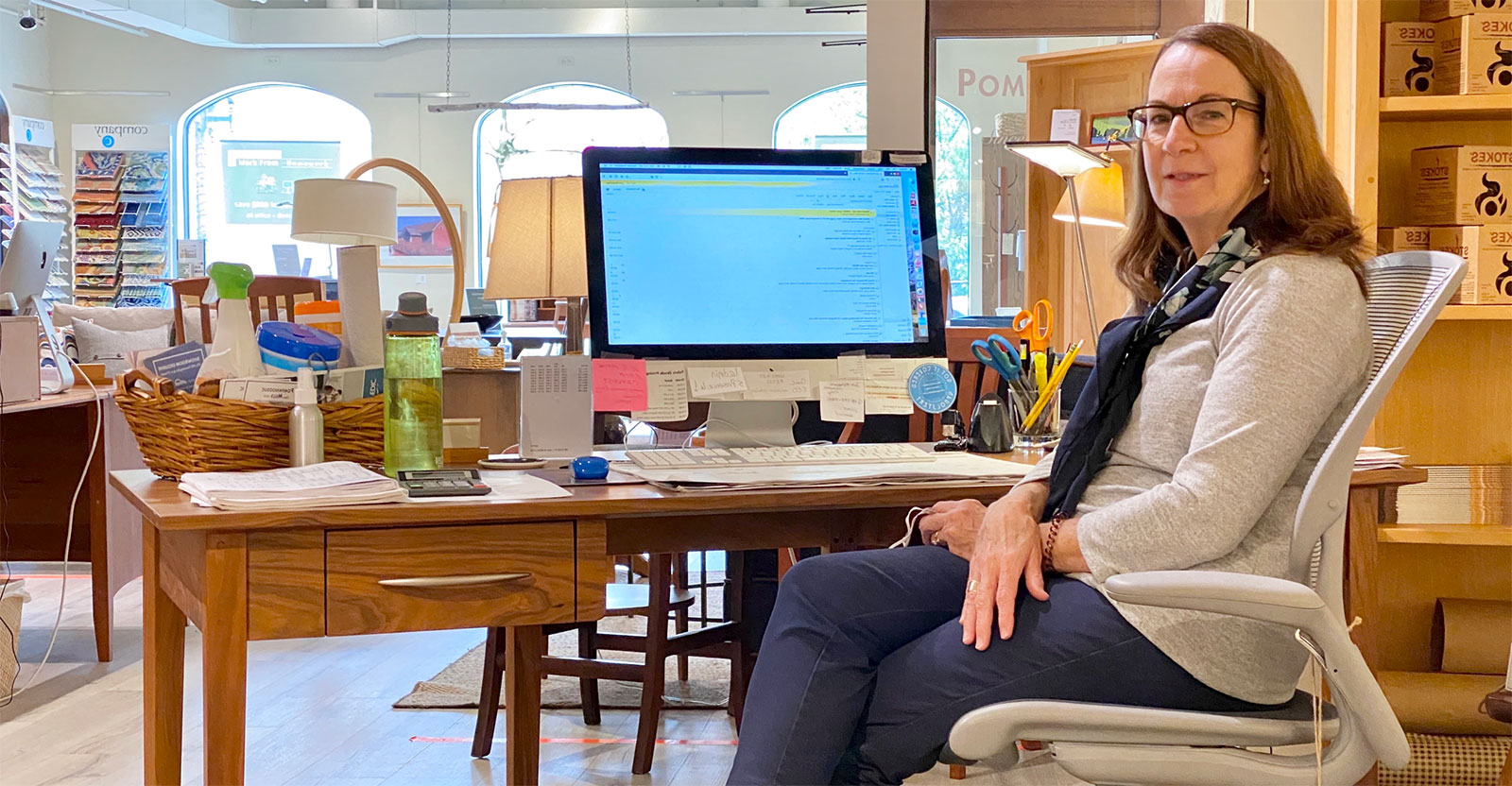 woman sitting a computer looking at camera