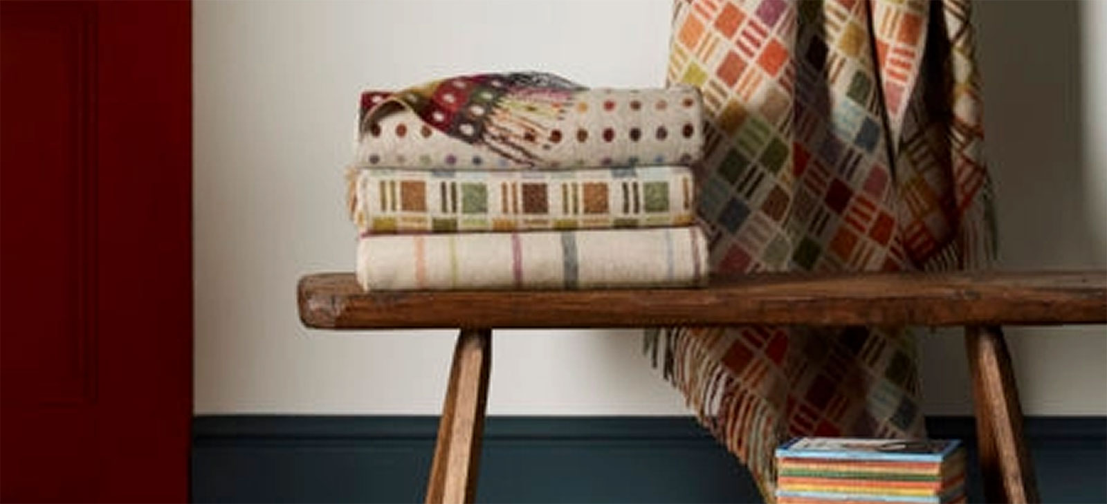 beautiful and colorful wood throws folded and stacked on a rustic wood bench