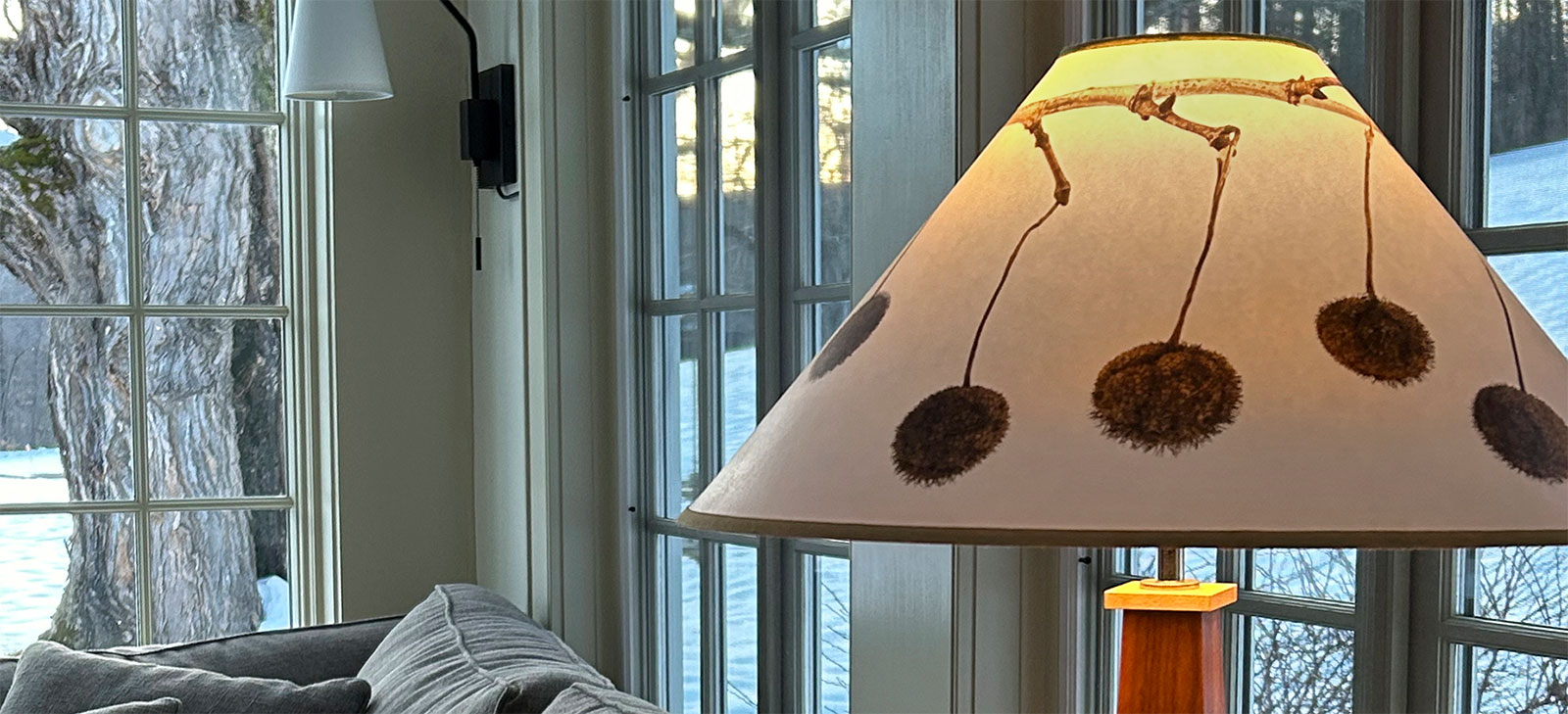 lamp with pods painted on the lampshade in a wintery house setting