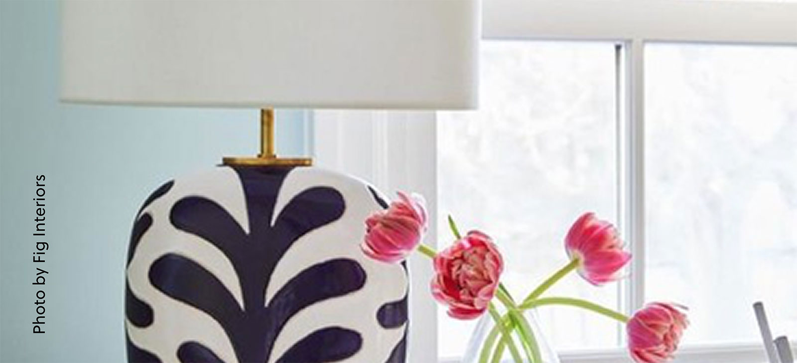 black and white ceramic lamp with pink tuips in a vase