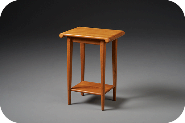 small end table with curved edges in cherry