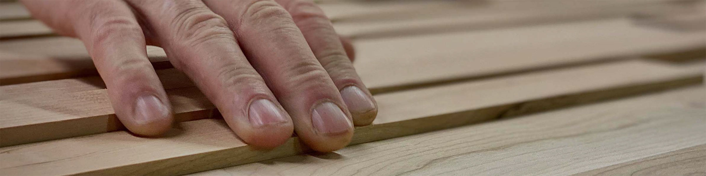 close up of a man's hand on a wood panel