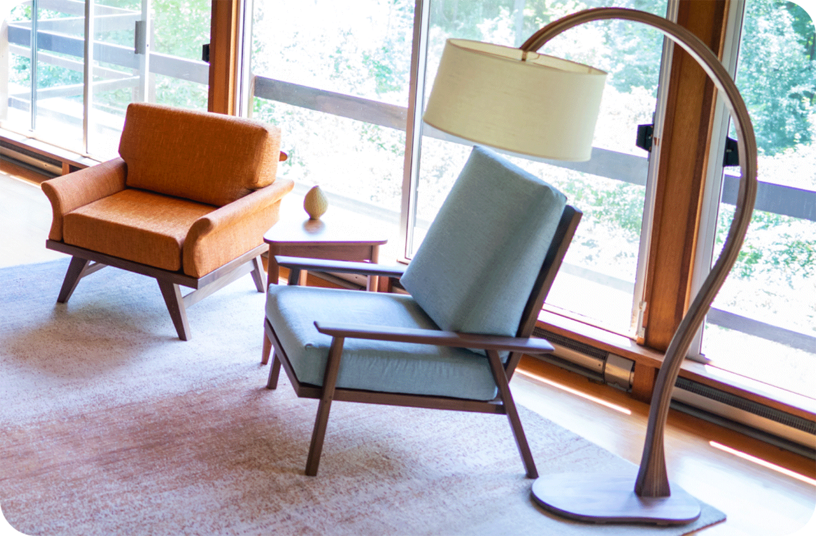 living room with 2 modern chairs and a large curved floor lamp