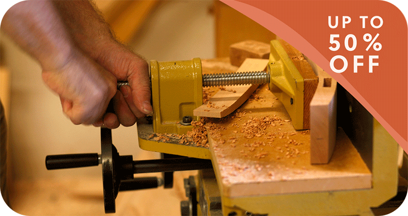a man's hands in a wood-working shop with up to 50% off banner