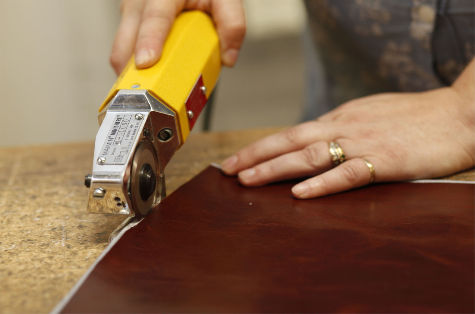 craftsperson cutting leather with shears