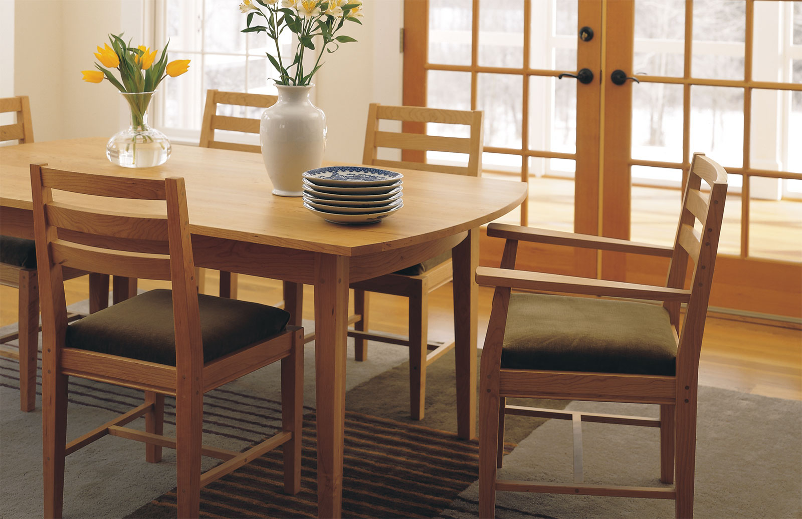 dining table with green velvet chairs in front of glass patio door