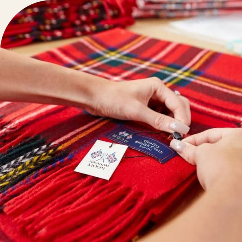 image of red plaid throw with hands attaching a label